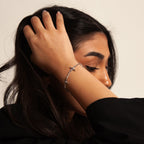 Ovis & Co. Celestial Armband Silber – minimalistisches Edelstahlarmband mit 5 filigranen Anhängern, getragen von Frau mit schwarzem Outfit, designed in Frankfurt