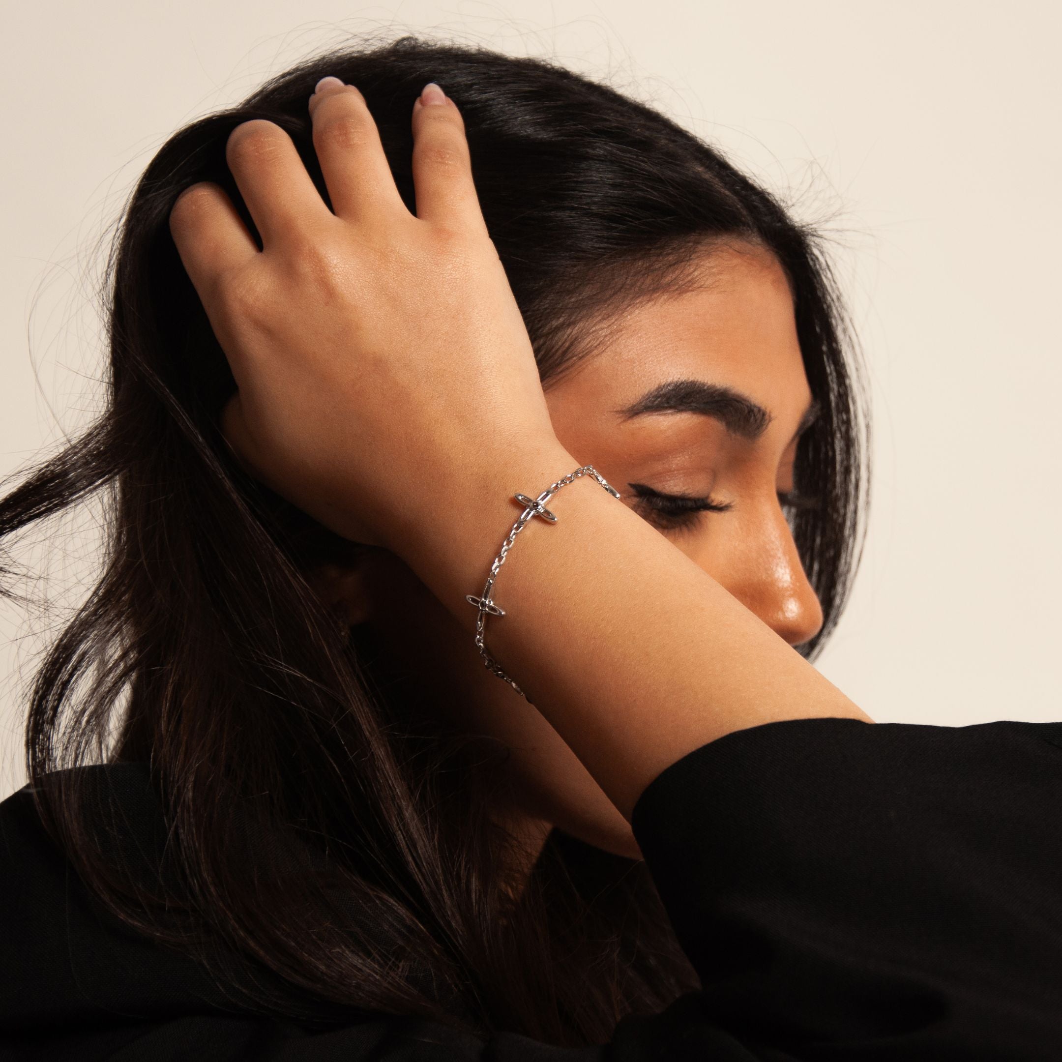 Ovis & Co. Celestial Armband Silber – minimalistisches Edelstahlarmband mit 5 filigranen Anhängern, getragen von Frau mit schwarzem Outfit, designed in Frankfurt
