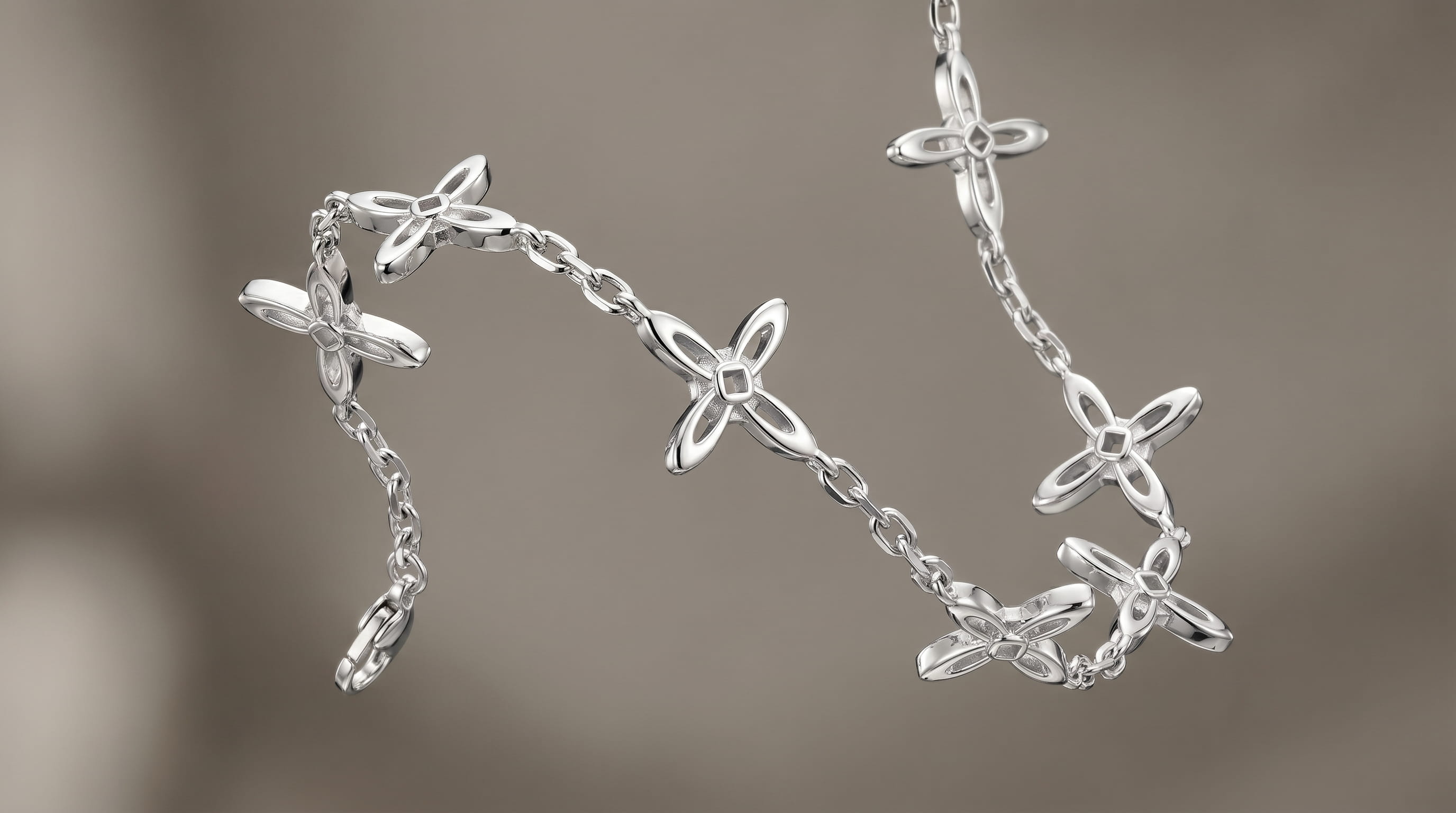 Ovis & Co. Celestial Armband Silber – Edelstahlarmband mit 5 filigranen Kreuz-Anhängern, freischwebend vor grauem Hintergrund, minimalistischer Schmuck designed in Frankfurt