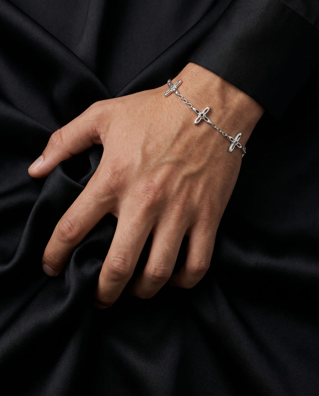 Ovis & Co. Celestial Armband Silber – Edelstahlarmband mit 5 filigranen Anhängern, getragen von Mann zu schwarzem Satin-Blazer, designed in Frankfurt