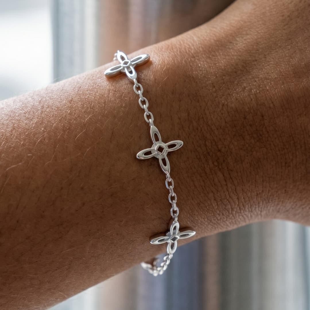 Ovis & Co. Celestial Armband Silber – Nahaufnahme der filigranen Kreuz-Anhänger am Handgelenk, Edelstahlarmband auf Haut, designed in Frankfurt