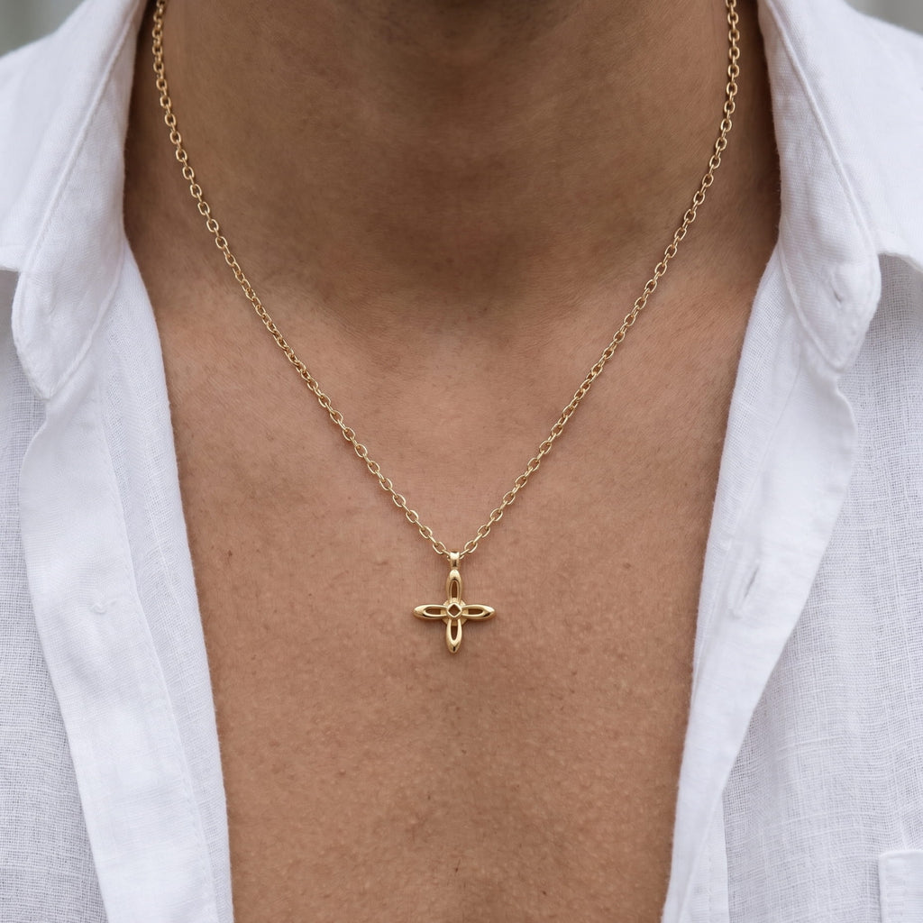 Ovis & Co. Celestial Kette Gold – minimalistische Edelstahlkette mit filigranem Kreuz-Anhänger, getragen von Mann mit offenem weißen Leinenhemd, langlebige Veredelung, designed in Frankfurt