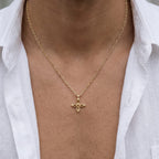 Ovis & Co. Celestial Kette Gold – minimalistische Edelstahlkette mit filigranem Kreuz-Anhänger, getragen von Mann mit offenem weißen Leinenhemd, langlebige Veredelung, designed in Frankfurt