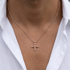 Ovis & Co. Celestial Kette Roségold – minimalistische Edelstahlkette mit filigranem Kreuz-Anhänger, getragen von Mann mit offenem weißen Leinenhemd, langlebige Veredelung, designed in Frankfurt