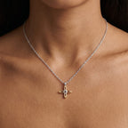 Ovis & Co. Celestial Kette Two-Tone – Edelstahlkette mit filigranem Kreuz-Anhänger in Silber und Gold, getragen von Frau auf nacktem Décolleté, designed in Frankfurt